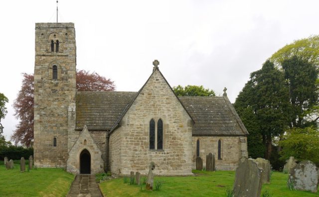 Photograph of St Andrew's Church in Bywell, showcasing its historic architecture against a backdrop of the serene village.