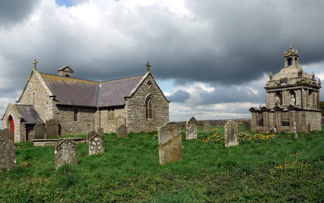 Photograph of St Andrew's Church alongside the Hopper Mausoleum on Greymare Hill, representing historical architecture amidst natural beauty.