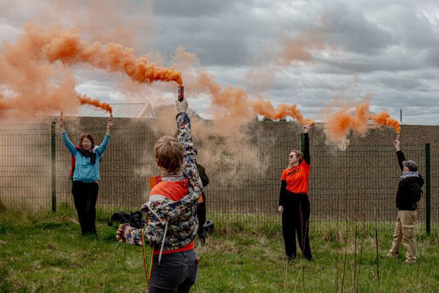 Protesters gather at Hassockfield, armed with signs and flares, to demand reforms in immigration detention policies. Their united stance highlights the community's call for justice and dignity for all detainees.