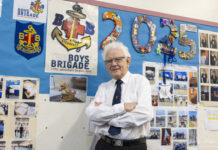 Lanchester Local Eric Hepplewhite Celebrated for Lifelong Community Impact Eric Hepplewhite standing in front of Boys Brigade display in Lanchester
