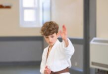 Building Confidence Through Karate A young karate student in a white gi and brown belt holding an open-hand block position during a class in Lanchester