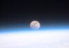 The Moon The full moon seen from orbit, sitting just above the blue curve of Earth's atmosphere with dark space above and cloud below