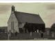 What a Postcard Revealed: the Story of Joseph Thompson Maddison A 1913 black and white postcard photograph of Muggleswick Church, a small stone church with a bellcote and ivy-covered wall, with two men in flat caps standing among the gravestones